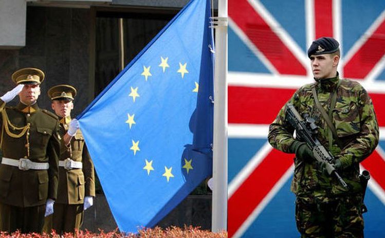 Un soldat britanic stă lângă steagul ţării sale, în timp ce alţi doi soldaţi salută lângă steagul UE.