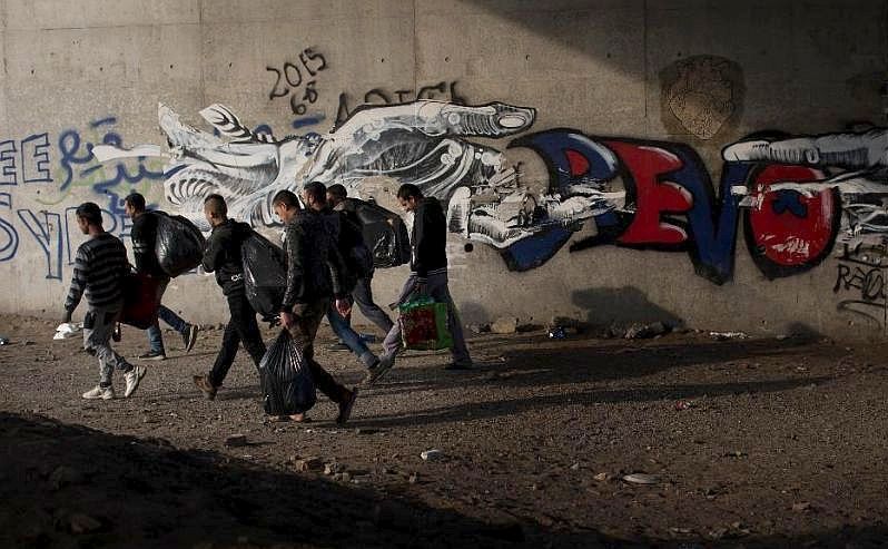 Un grup de imigranţi părăsesc tabăra “Jungla” din oraşul francez Calais, 23 octombrie 2016.